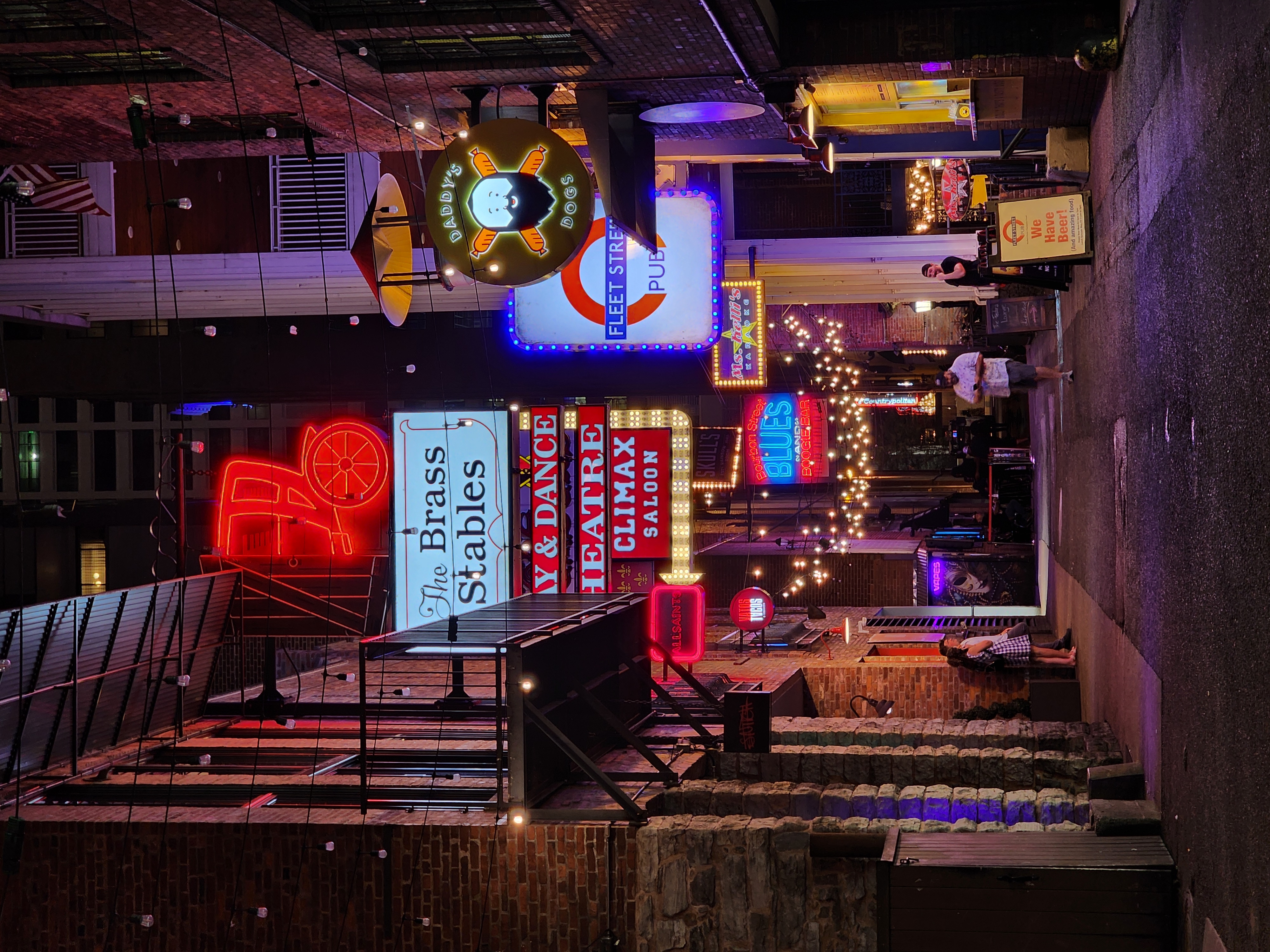 Neon signs and entrances along Printer's Alley at night.